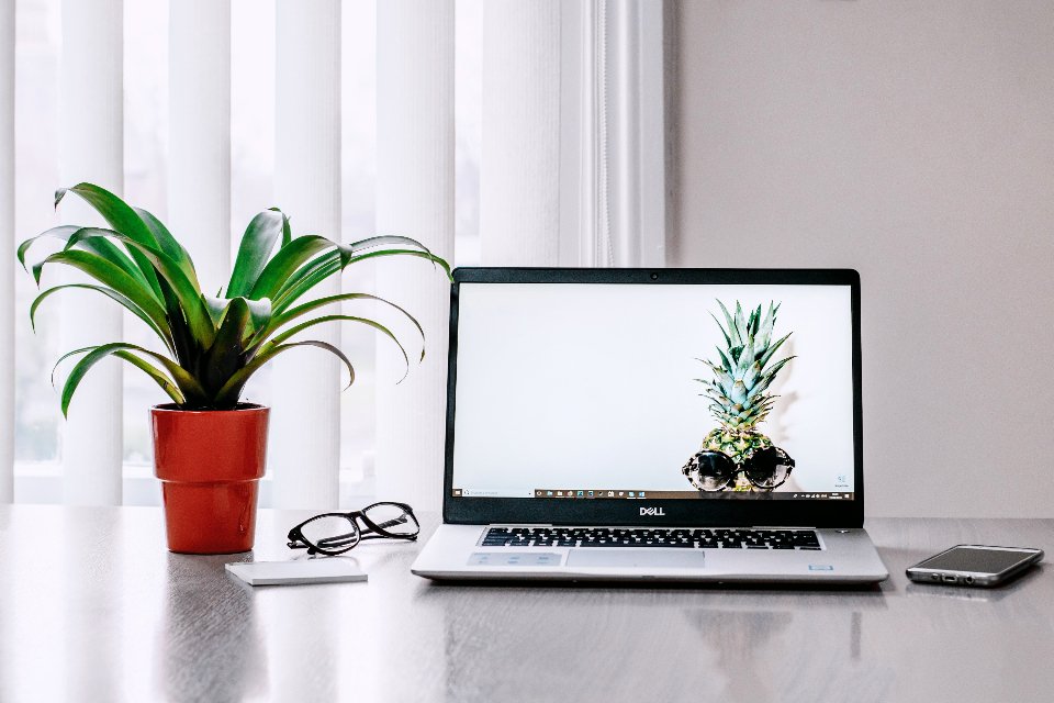 A laptop on a desk next to a phone, the tools for checking a business website